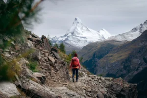 Hiker traversing high alpine pass with Matterhorn in the distance