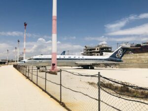 Former Olympic Airlines terminal at Ellinikon with weeds growing through tarmac