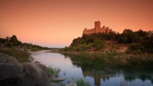 Medieval Almourol castle rising from a river island at sunset