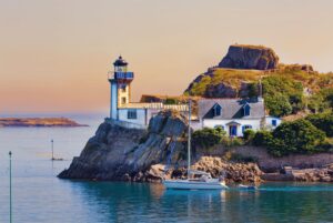 Tiny Île Louët with a white lighthouse and two stone cottages off Brittany’s coast
