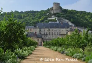 The cliff-top keep of La Roche-Guyon rising above Seine-side kitchen gardens