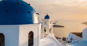 Blue-domed chapel framed by whitewashed houses on the hilltop of Pyrgos