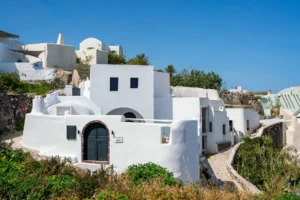 Restored cave houses with colorful doors and bougainvillea in Finikia village