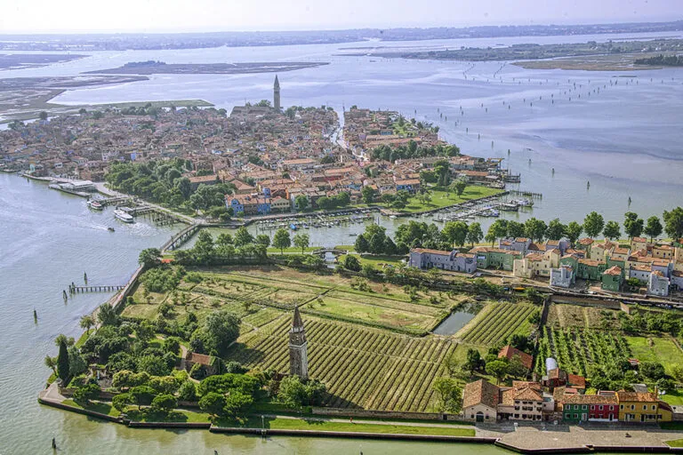 Aerial view of Mazzorbo’s Venissa vineyard wrapped by Venice Lagoon canals—no cars in sight