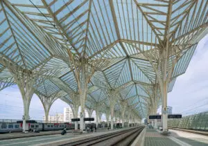 Lisbon Oriente station showing solar canopies over platforms and the Solaris train connected to charging arms