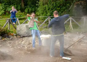 Locals lifting Cozido stew pots from geothermal ground holes at Furnas