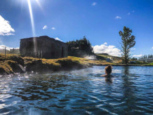 Secret Lagoon geothermal pool with mist rising at Fludir